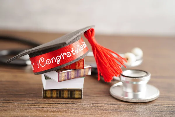 Graduation hat on book and stethoscope with copy space, doctor learning medicine university education concept.