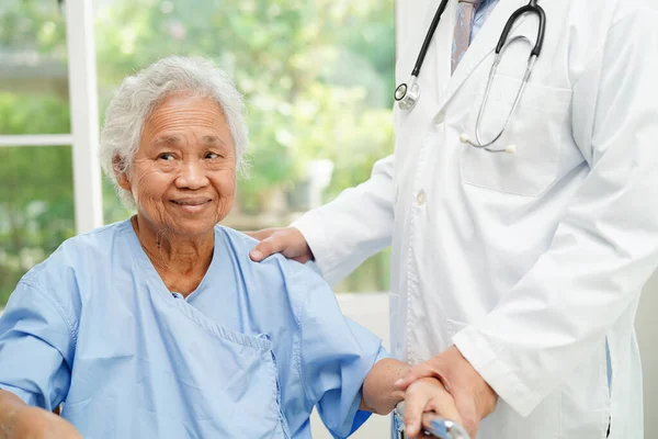 Stock image Doctor help Asian elderly woman disability patient walk with walker in nursing hospital, medical concept.