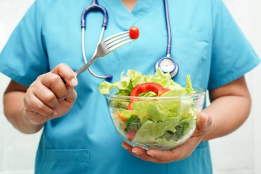 Asyalı Beslenme Uzmanı hastalar için sağlıklı yiyecekler, beslenme ve vitamin tutuyor..