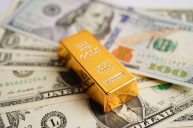 Gold bars on US dollar banknote money, finance trading investment business currency concept. 