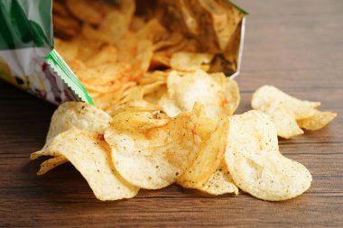 Açık pakette patates cipsi, Crips için baharatlı barbekü sosu, açık torbada ince dilimlenmiş kızarmış fast food..