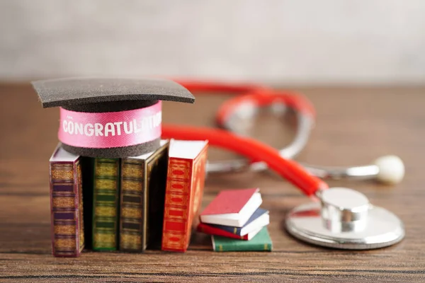 Graduation hat on book and stethoscope with copy space, doctor learning medicine university education concept.