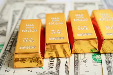 Gold bars on US dollar banknote money, finance trading investment business currency concept. 