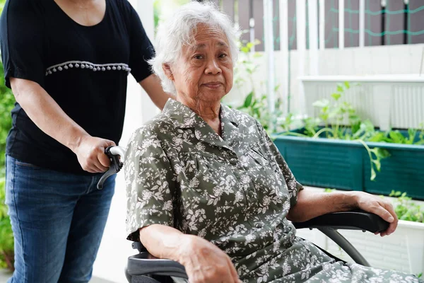 护理人员帮助坐在轮椅上的亚洲老年残疾妇女 医疗理念 — 图库照片