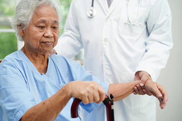 医師の助けアジアの高齢者の障害者の女性病院でしわの手で杖を保持 — ストック写真