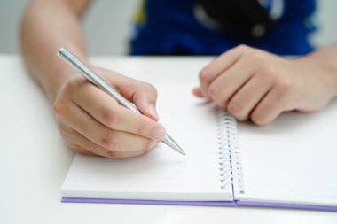 Asyalı genç öğrenci ödev yazar, online öğrenim eğitimi sınavı için ders çalışır..