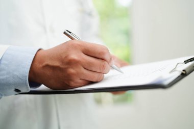 Doktor kontrol ediyor ve teşhis ilacını hastanedeki hastaların dosyalarına not ediyor..