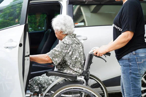 介護者は アジアの高齢女性障害患者が彼女の車に乗るのを助ける 医療の概念 — ストック写真
