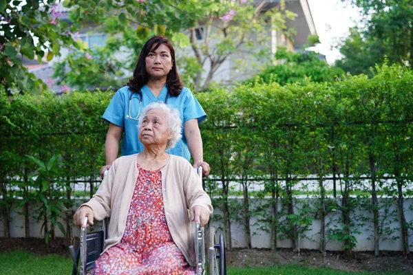 亚洲老年残疾妇女坐在公园轮椅上的医疗理念 — 图库照片