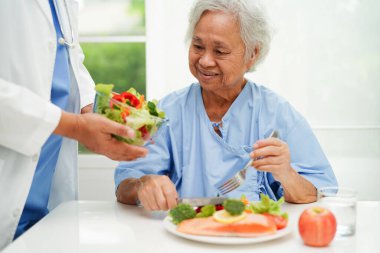 Asyalı Beslenme Uzmanı hastalar için sağlıklı yiyecekler, beslenme ve vitamin tutuyor..