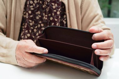 Retired elderly woman counting coins money and worry about monthly expenses and treatment fee payment.