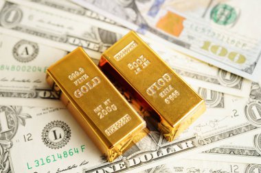 Gold bars on US dollar banknote money, finance trading investment business currency concept. 