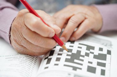 Bunama ve Alzheimer hastalıklarını önlemek için beyin eğitimi için sudoku oyunu oynayan Asyalı yaşlı kadın..