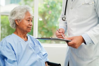 Doktor kontrol ediyor ve teşhis ilacını hastanedeki hastaların dosyalarına not ediyor..