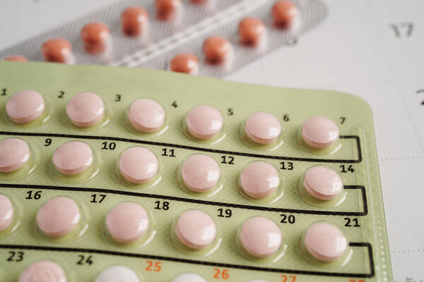 Pregnancy test with birth control pills for female on calendar, ovulation day.