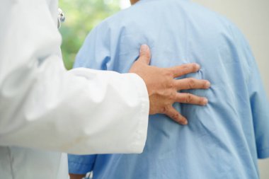 Doktor, Asyalı yaşlı kadın engelli hastaya hemşirelik hastanesinde Walker 'la birlikte yürümesi için yardım ediyor..