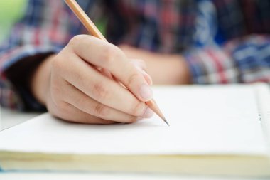 Asyalı genç öğrenci ödev yazar, online öğrenim eğitimi sınavı için ders çalışır..