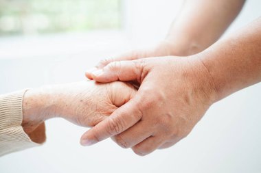 Bakıcı el ele tutuşuyor Asyalı yaşlı kadın hasta, hastanede yardım ve bakım.