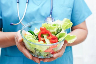 Asyalı Beslenme Uzmanı hastalar için sağlıklı yiyecekler, beslenme ve vitamin tutuyor..