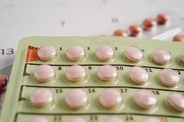Birth control pills for female on calendar, ovulation day.