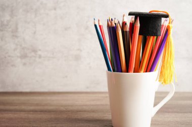 Fotokopi alanı olan renkli kalemli mezuniyet şapkası, üniversite eğitimi kavramı..