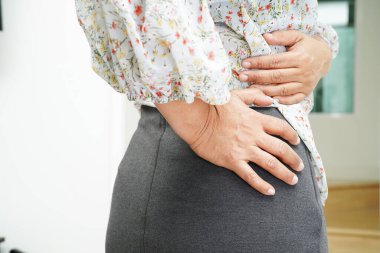 Asyalı kadın şişman göbek gösteriyor. Ofiste kilolu ve obez..