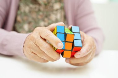 Bangkok, Tayland - 15 Mayıs 2022 Asyalı yaşlı kadın bunama ve Alzheimer hastalıklarına karşı beyin eğitimi için oyun oynuyor.