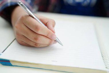 Asyalı genç öğrenci ödev yazar, online öğrenim eğitimi sınavı için ders çalışır..