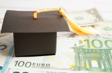 Avrupa ve ABD doları üzerindeki mezuniyet şapkası para, eğitim ücreti öğrenim öğrenimi öğretim konsepti.