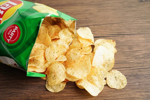 stock image Bangkok, Thailand - May 15, 2022 Potato chips in open bag, delicious BBQ seasoning spicy for crips, thin slice deep fried snack fast food in open bag.