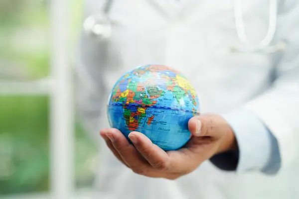 stock image Asian man doctor holding globe, Elements of this image furnished by NASA.