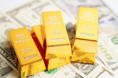Gold bars on US dollar banknote money, finance trading investment business currency concept. 