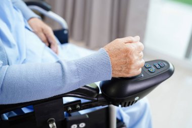 Parkta elektrikli sandalyede oturan Asyalı yaşlı kadın engelli hasta, tıbbi konsept..