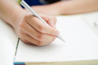 Asyalı genç öğrenci ödev yazar, online öğrenim eğitimi sınavı için ders çalışır..