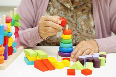 Asyalı yaşlı kadın bunama ve Alzheimer hastalıklarının tedavisi için bulmaca oyunu oynuyor.