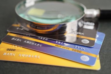Credit card and magnifying glass for online shopping, security finance business concept.