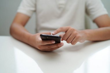 İletişim için akıllı telefon kullanan genç, öğrenmek için veri web sitesi ara.