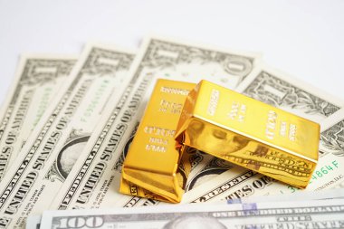 Gold bars on US dollar banknote money, finance trading investment business currency concept. 