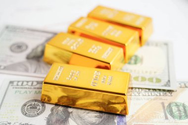 Gold bars on US dollar banknote money, finance trading investment business currency concept. 
