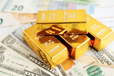 Gold bars on US dollar banknote money, finance trading investment business currency concept.