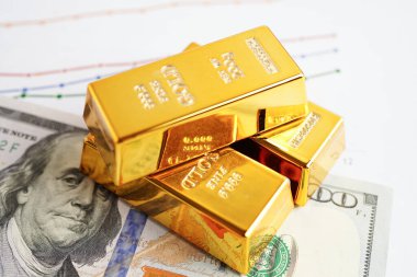 Gold bars on US dollar banknote money, finance trading investment business currency concept. 