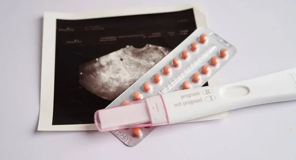Pregnancy test with ultrasound scan photo of fetus, maternity, childbirth, birth control.
