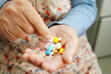 Asyalı yaşlı kadın elinde hap tutuyor, güçlü sağlıklı tıbbi konsept.. 