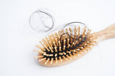 Tarak fırçasıyla beyaz arkaplanda saç kaybı.