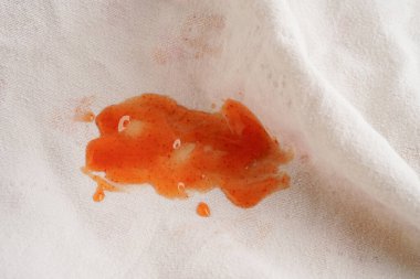 Kirli domates sosu lekesi ya da çamaşır tozuyla yıkamak için ketçap, ev işi konsepti..