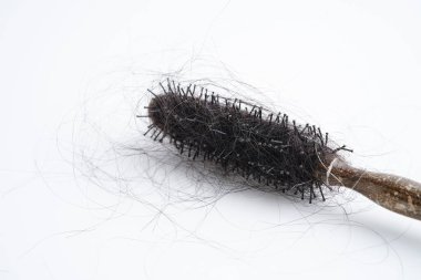 Tarak fırçasıyla beyaz arkaplanda saç kaybı.