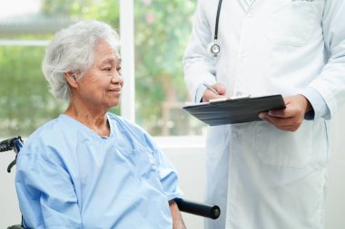 Doktor kontrol ediyor ve teşhis ilacını hastanedeki hastaların dosyalarına not ediyor..