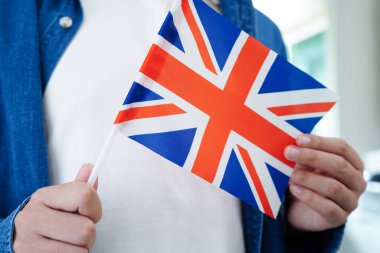 İngilizce öğrenen Asyalı ergen öğrenci, dil eğitimi için bayrak tutuyor..