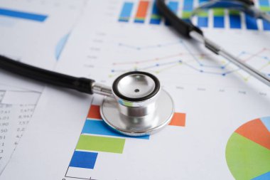 Çizelge ya da grafik kağıdı, Finansal, hesap, istatistik ve iş verileri medikal sağlık kavramı üzerine steteskop ve ABD doları banknotları.