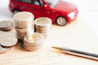 Bangkok, Thailand January 20, 2022 Car on coins money, saving bank, finance, installment payment, car loan interest.